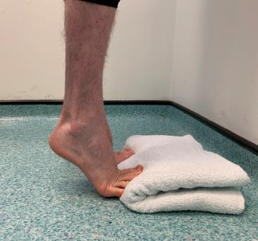 Standing on tip toes with toes on towel